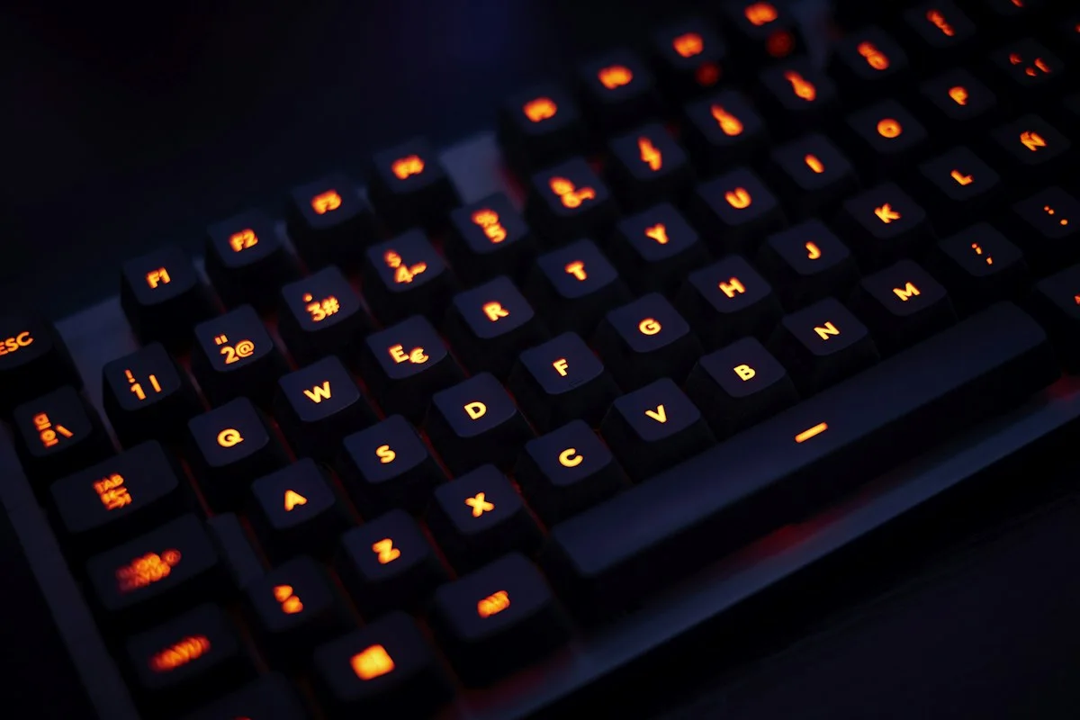 Eine schwarze Computertastatur auf einer dunklen Oberfläche.