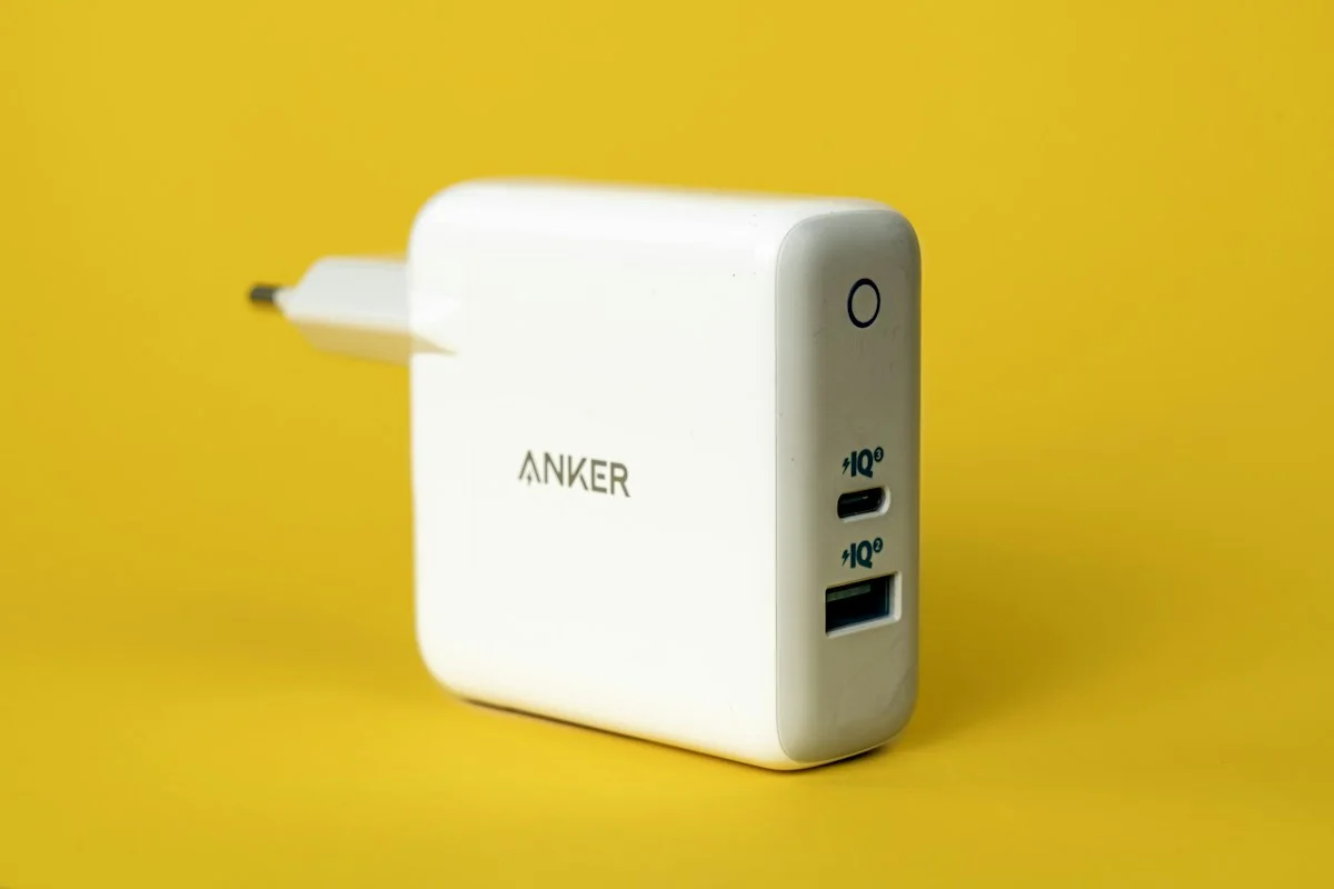 Weißes USB-Netzteil auf gelbem Untergrund – Symbolfoto zum Prüfen der Stromversorgung