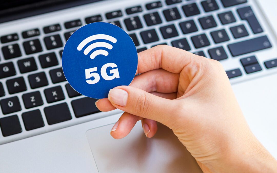 langsames Internet man sieht einen Laptop und eine Hand die ein Zeichen in der Hand hält wo 5G draufsteht.